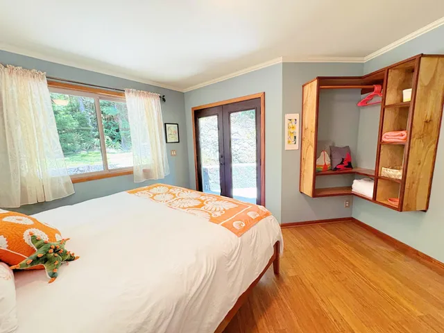 a bedroom with a bed and wooden floor