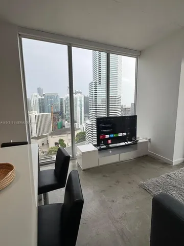 a living room with furniture and a floor to ceiling window