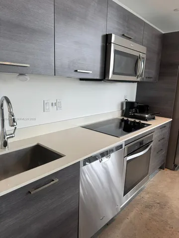 a kitchen with stainless steel appliances granite countertop a sink and a microwave