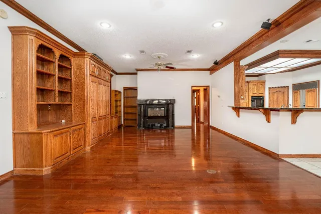 a view of empty room with wooden floor and seating space