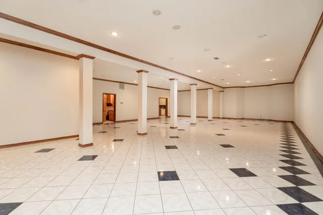 a view of a hallway with two windows and a chandelier