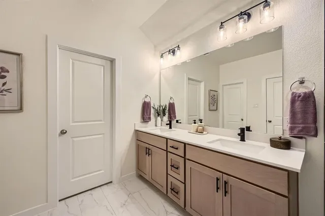 a bathroom with a double vanity sink and a mirror