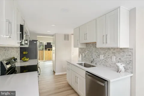 a kitchen with stainless steel appliances granite countertop a sink stove and cabinets