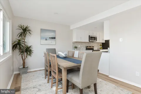 a dining room with furniture and a potted plant