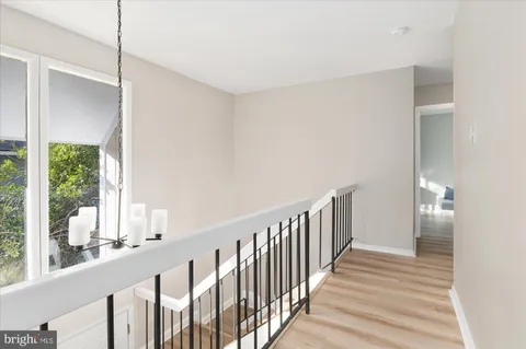 a view of a hallway with wooden floor and windows