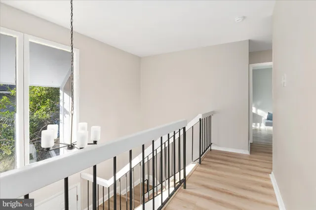 a view of a hallway with wooden floor and windows