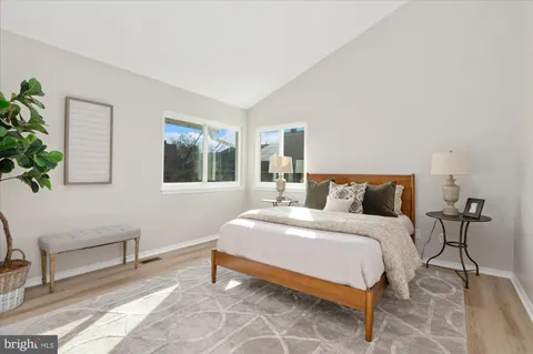 a bedroom with bed and a potted plant on dresser
