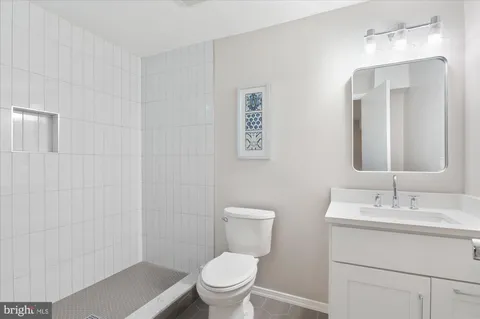 a bathroom with a toilet a sink a mirror and a shower