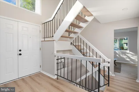 a view of staircase with railing and white walls