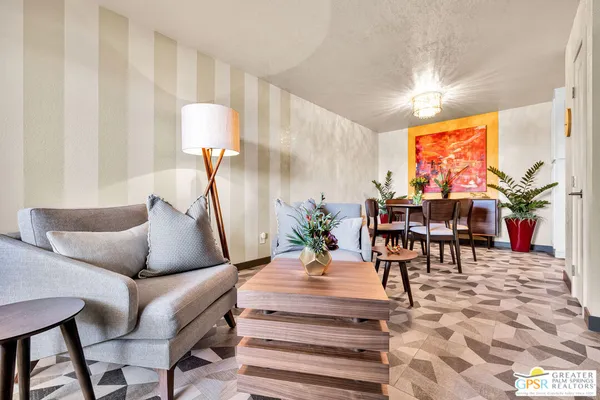 a living room with furniture a chandelier and a rug