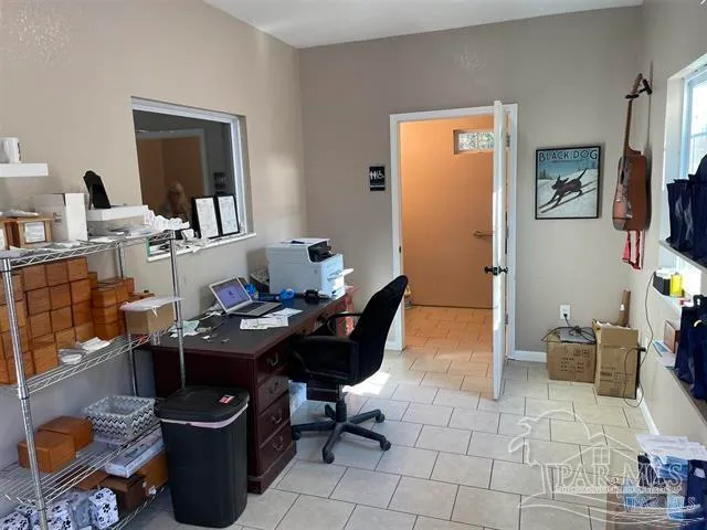 a work room with furniture a flat screen tv and a window