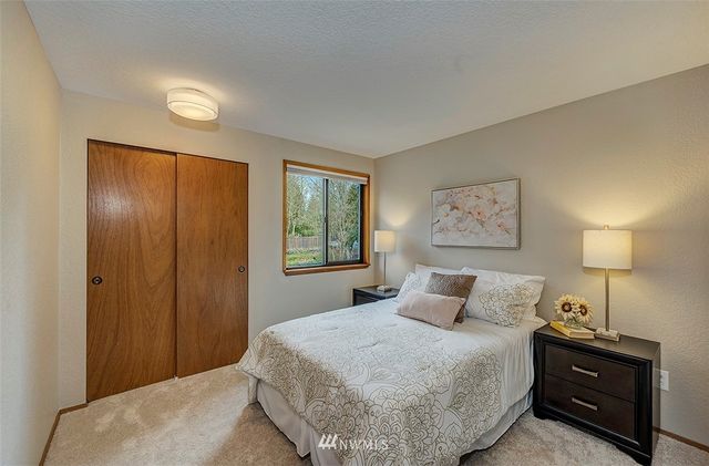 a bedroom with a bed and a lamp on dresser