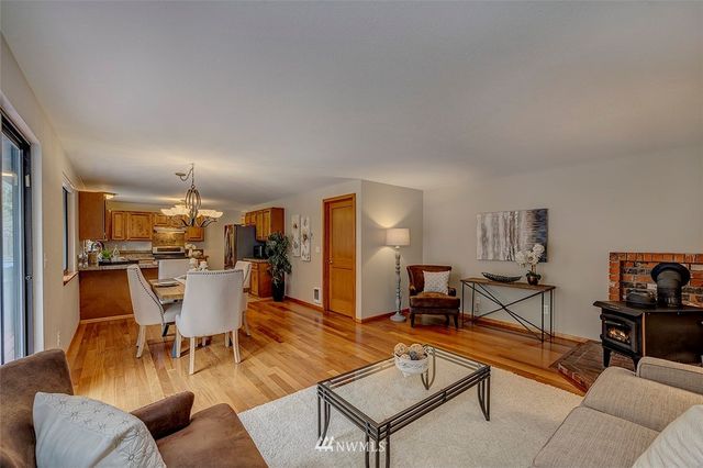 a living room with furniture a dining table and chairs with wooden floor