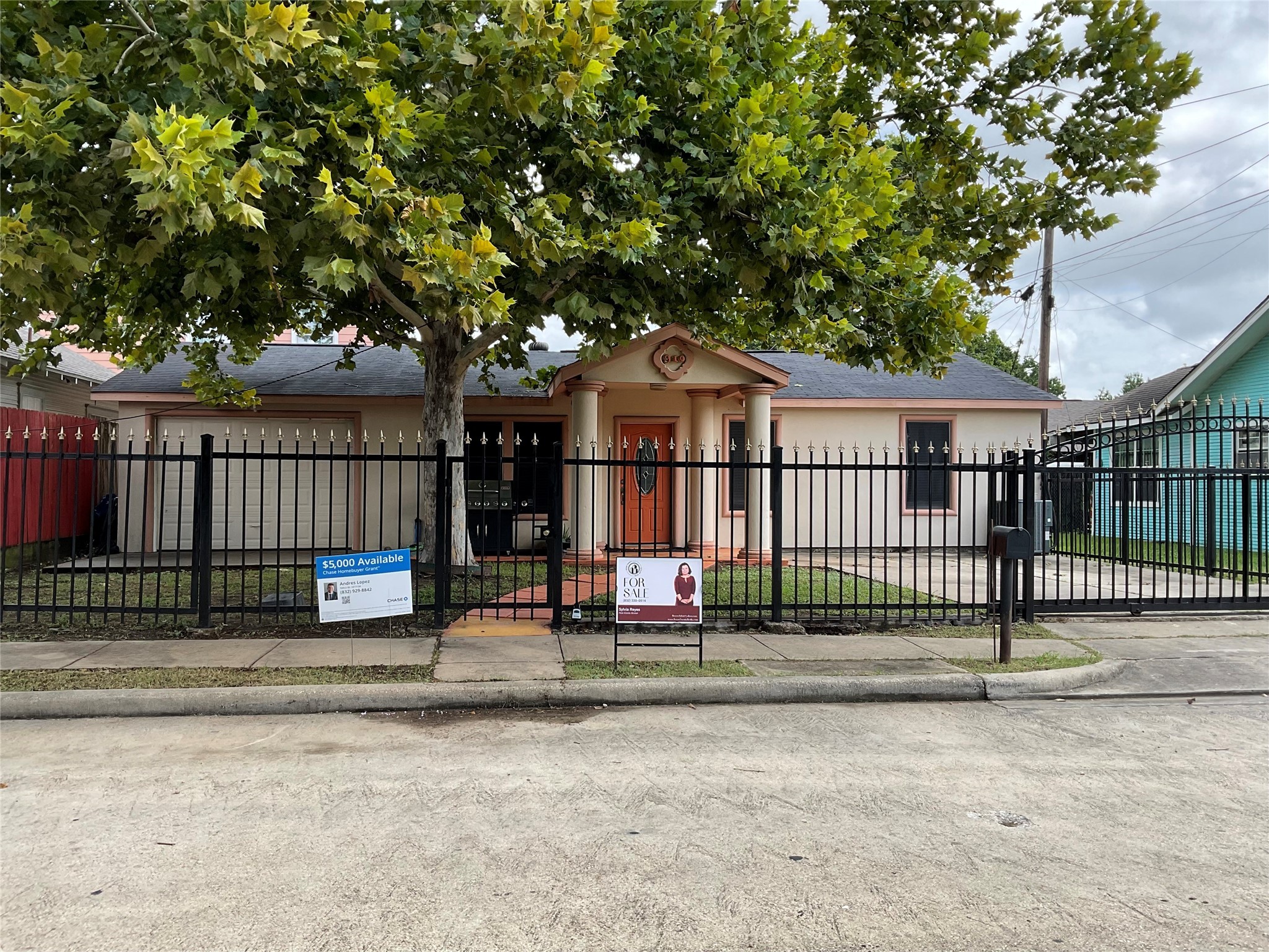 a view of a house with a small yard and wooden fence