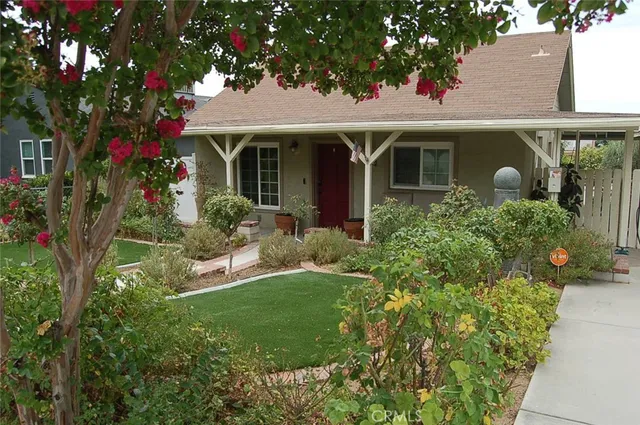 a front view of a house with a yard and potted plants
