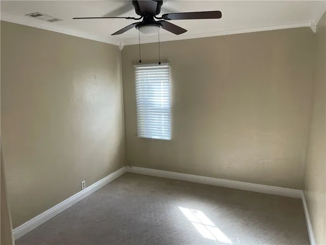 an empty room with a window and a fan