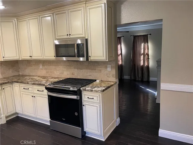 a kitchen with granite countertop a stove and a sink