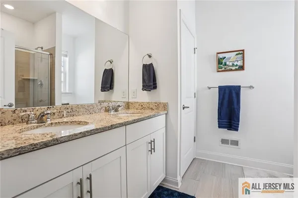a bathroom with a granite countertop sink and a mirror