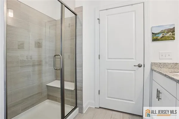 a bathroom with a granite countertop sink a mirror and a shower