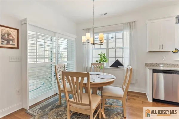 a dining room with furniture a chandelier and wooden floor
