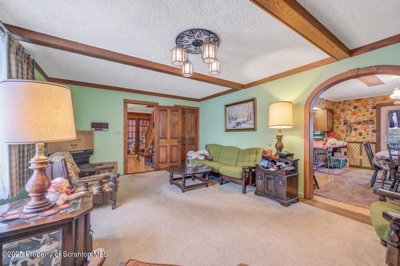 828 Glenwood Road Old Forge, PA 18518 - Photo 15 of 97 a living room with furniture a window and a chandelier