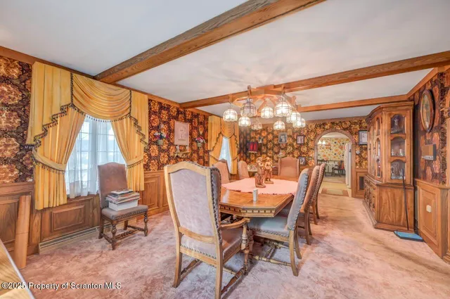 a spacious bedroom with a bed a dresser and a chandelier