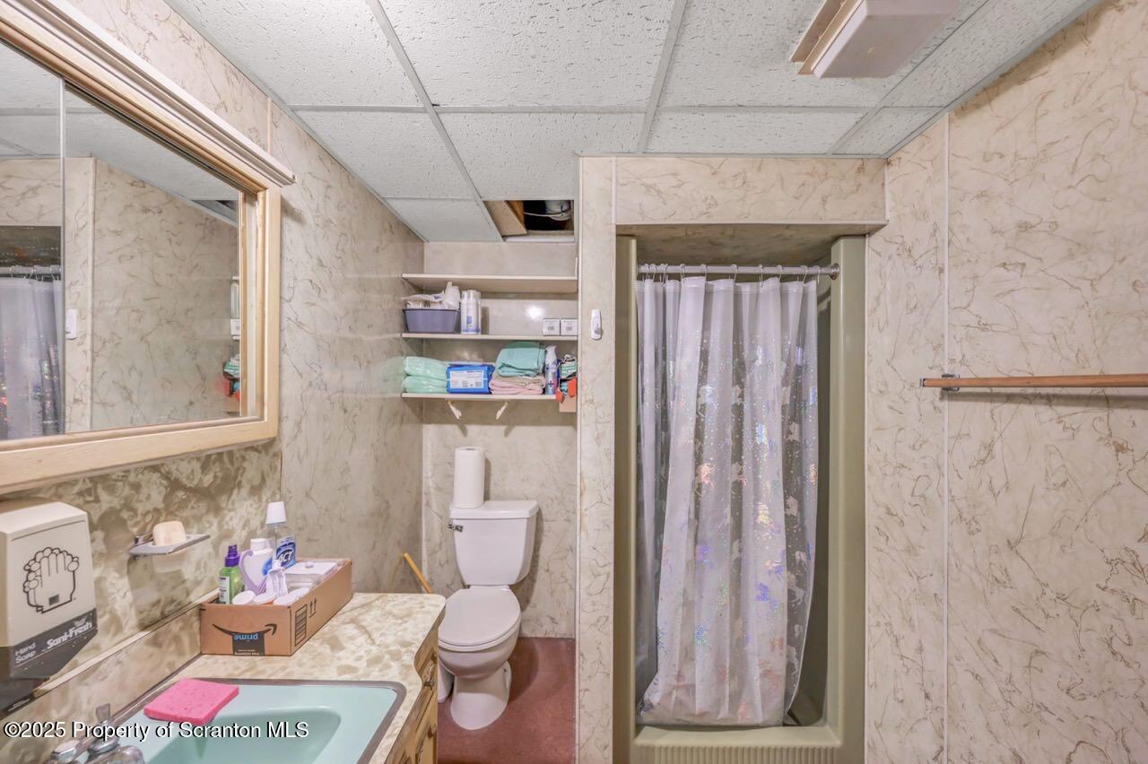 828 Glenwood Road Old Forge, PA 18518 - Photo 76 of 97 a bathroom with a toilet a sink and shower curtain