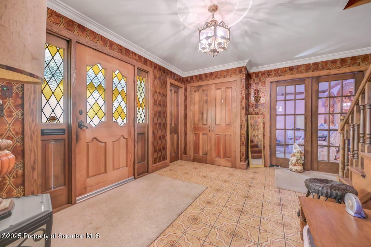 828 Glenwood Road Old Forge, PA 18518 - Photo 9 of 97 a spacious bedroom with a large bed and a chandelier