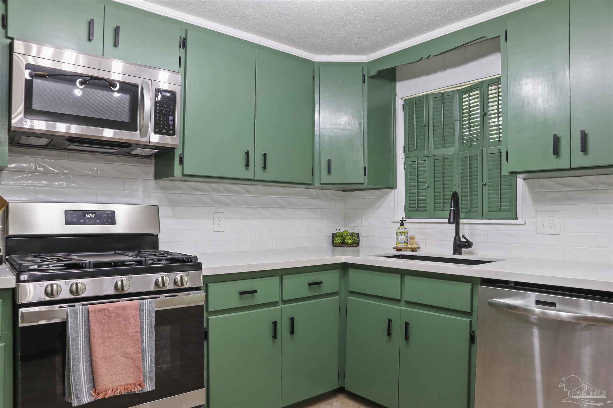 5925 Prince Road Pensacola, FL 32503 - Photo 11 of 51 a kitchen with cabinets a sink and a stove top oven