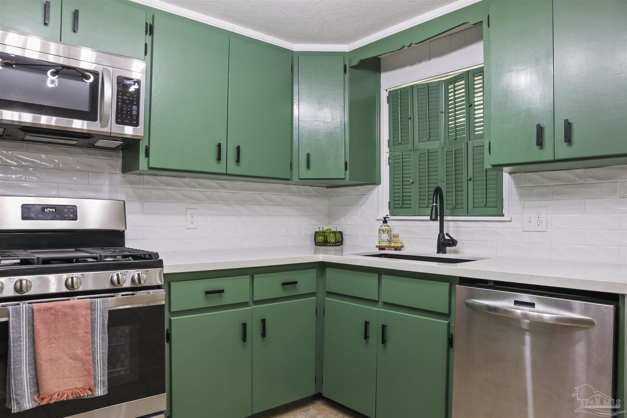 5925 Prince Road Pensacola, FL 32503 - Photo 13 of 51 a kitchen with a sink cabinets and stainless steel appliances