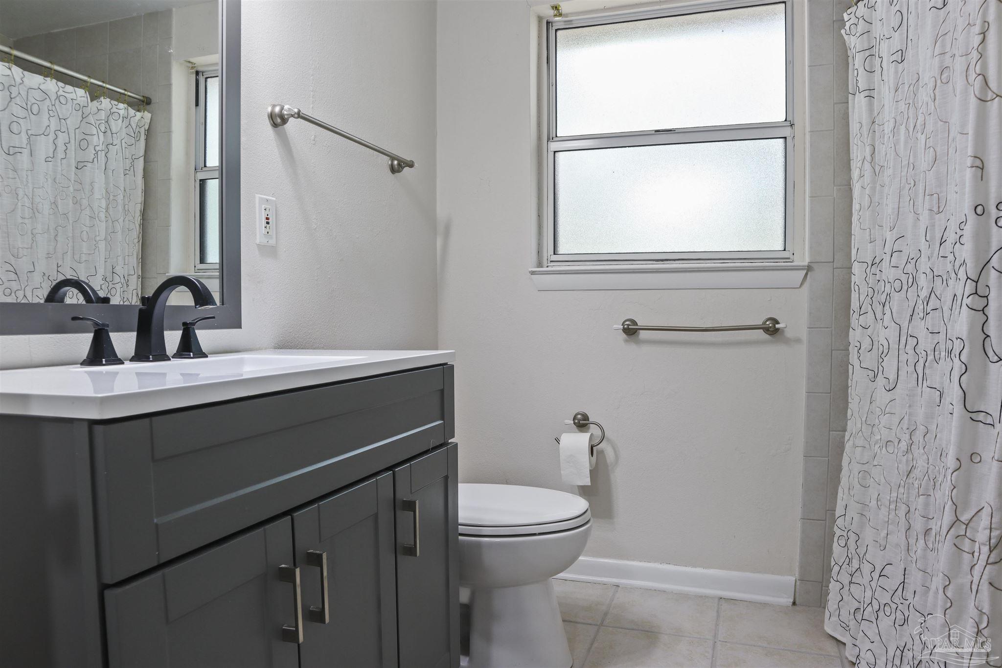 5925 Prince Road Pensacola, FL 32503 - Photo 33 of 51 a bathroom with a sink a toilet and a mirror