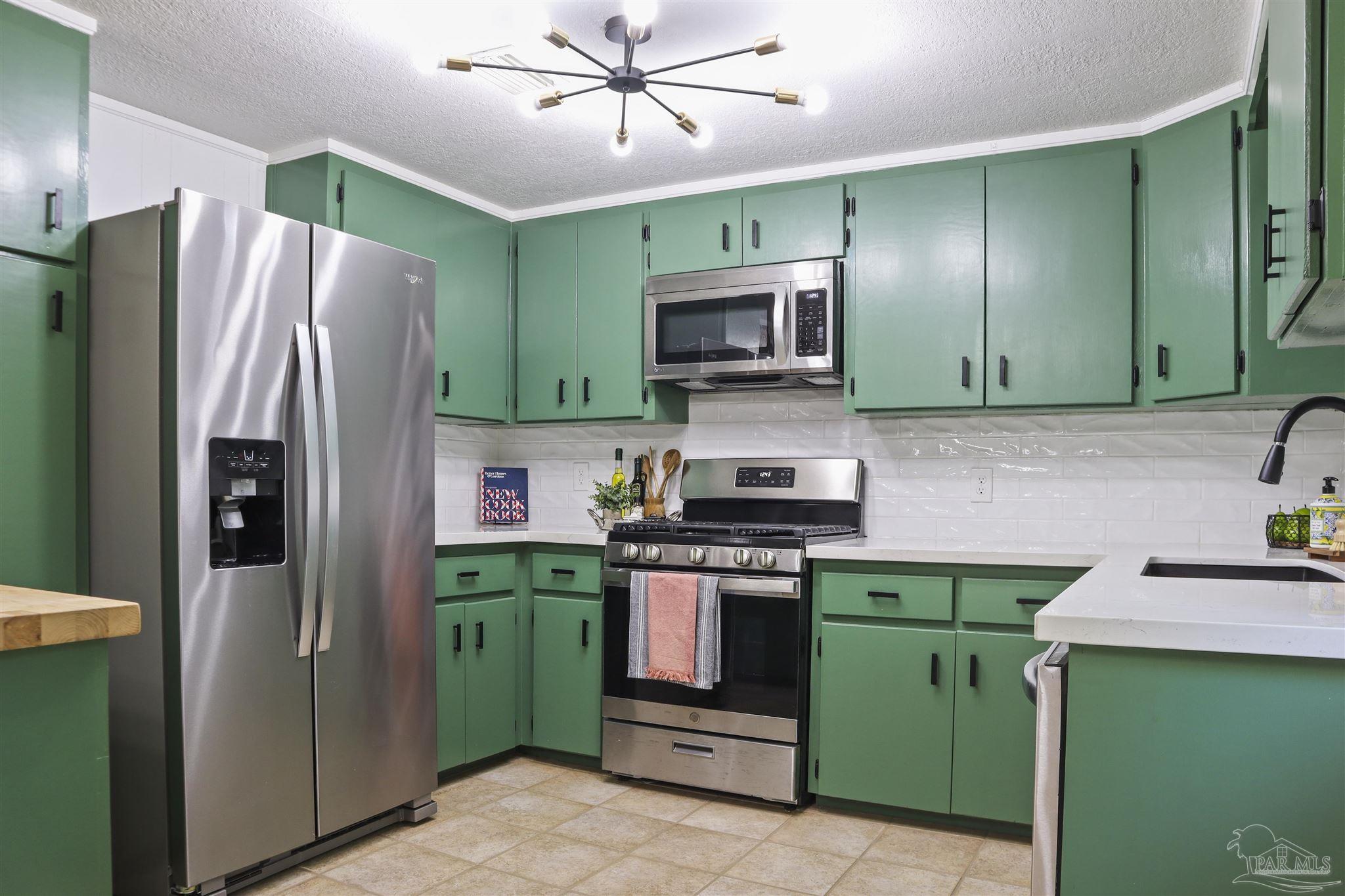 5925 Prince Road Pensacola, FL 32503 - Photo 10 of 51 a kitchen with a sink a refrigerator and a stove top oven