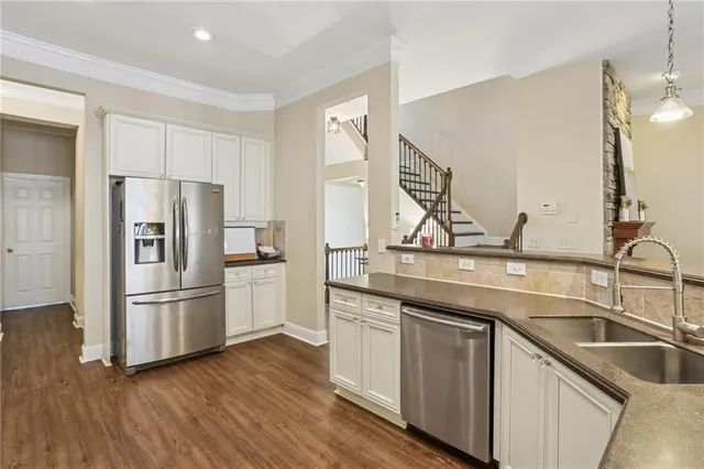 a kitchen with kitchen island granite countertop a refrigerator and a sink