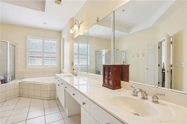 a spacious bathroom with a double vanity sink a large mirror and shower