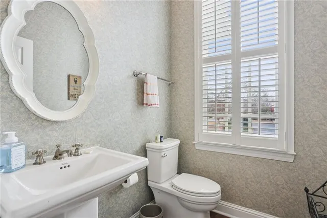 a bathroom with a sink a toilet and a mirror