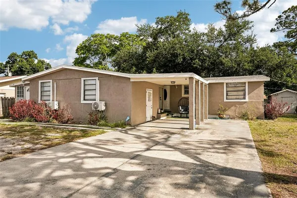 a view of a house with backyard and trees