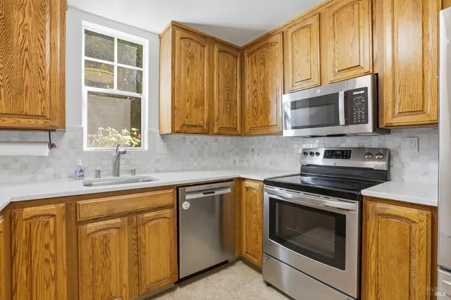 a kitchen with stainless steel appliances granite countertop a stove microwave and sink