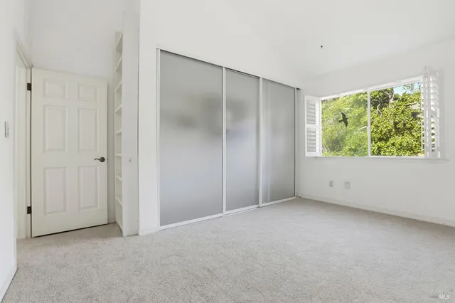 an empty room with windows and closet