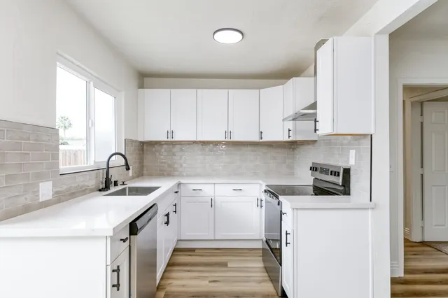 a kitchen with a sink stove and cabinets