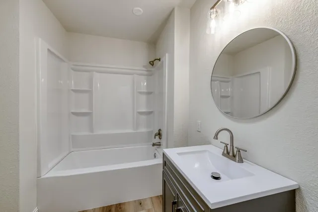 a bathroom with a sink a bathtub and a mirror