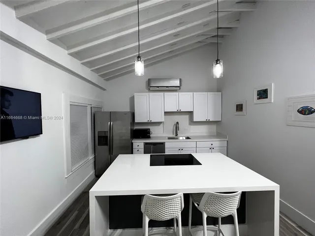 a kitchen with a dining table chairs refrigerator and cabinets