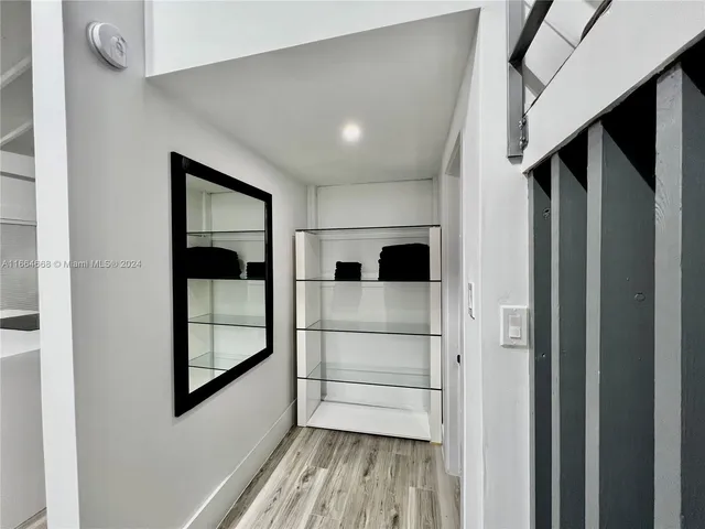 a view of a hallway with wooden floor and staircase