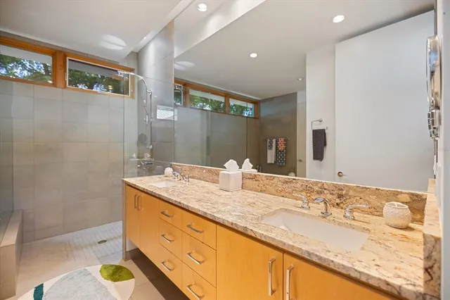 a bathroom with a granite countertop sink toilet and mirror