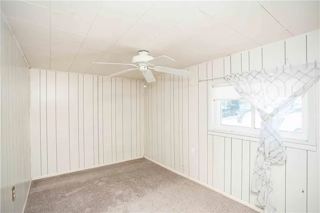 a view of a room with a white ceiling fan and window