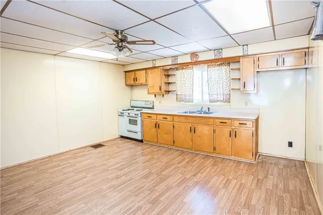 a kitchen with a sink cabinets and wooden floor