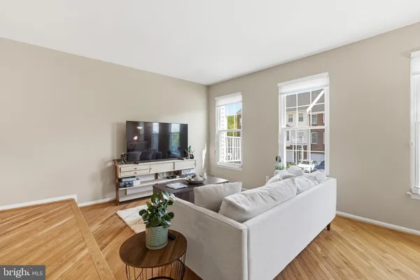 a view of a room with a ceiling fan and hardwood floor