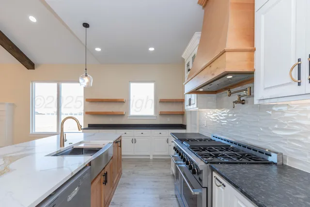 a kitchen with stainless steel appliances granite countertop a sink stove and cabinets
