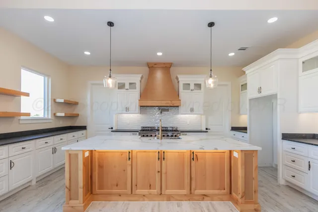 a kitchen with stainless steel appliances granite countertop a sink refrigerator and cabinets