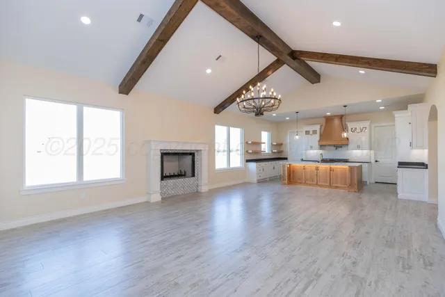a view of a big room with wooden floor and a kitchen