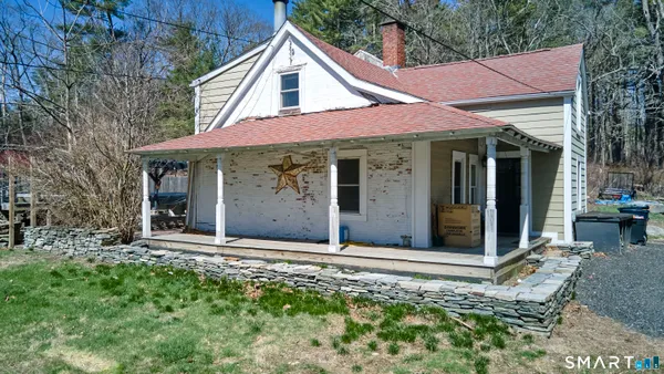 a view of a white house with large windows and a yard